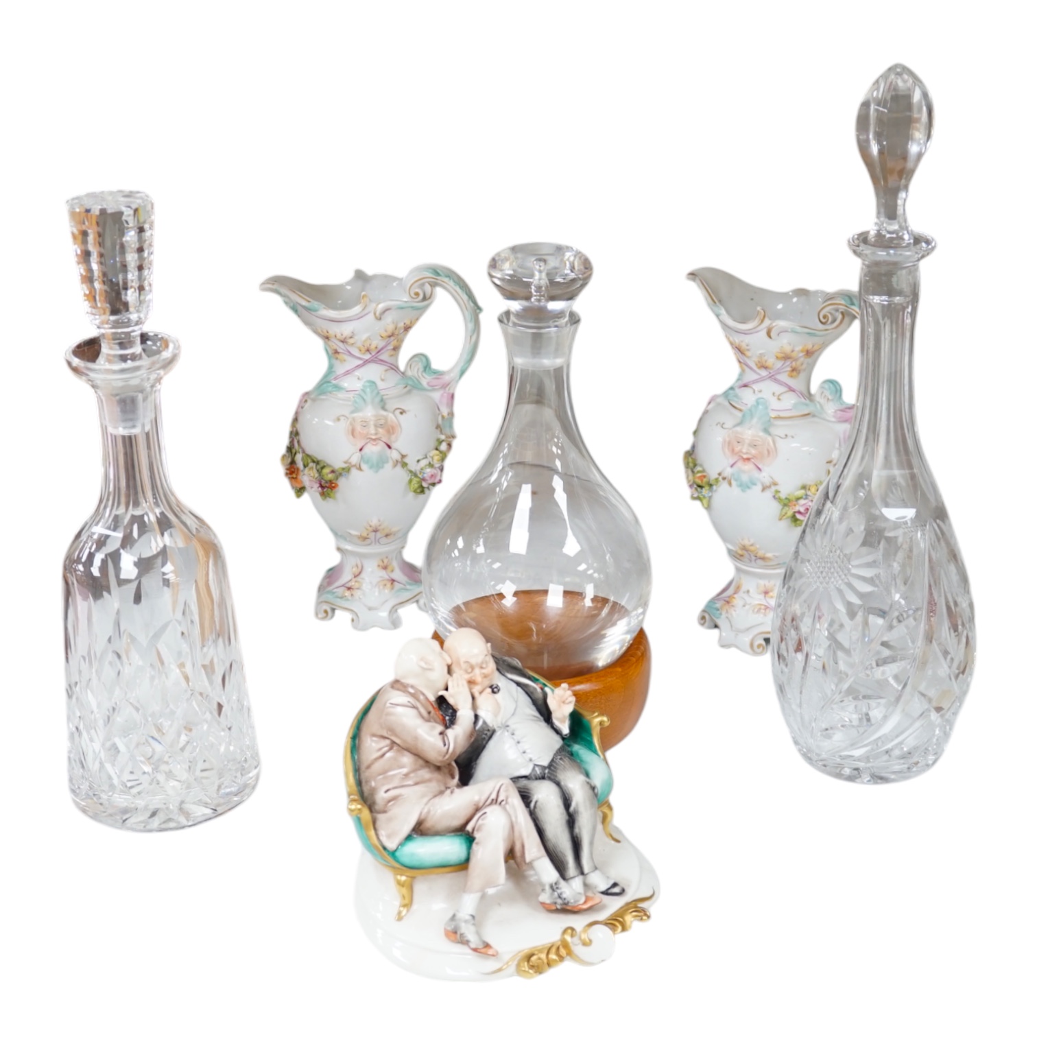 A collection of glassware and ceramics comprising Waterford decanter, two other decanters, German porcelain, ewers and a figure group, largest 40cm high. Condition - varies